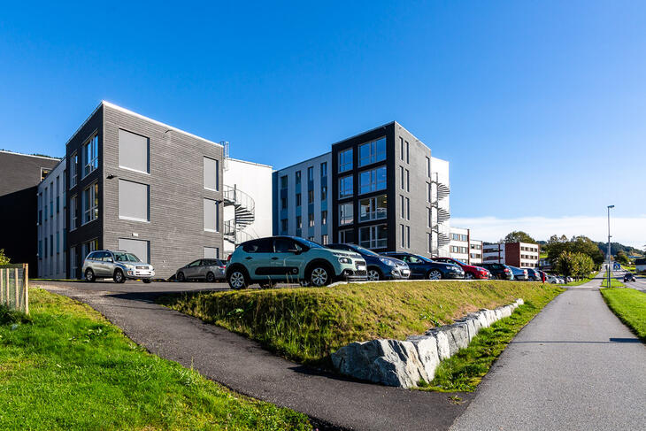 foto av Heltne studentheim, moderne bygg med bilar i framkant.